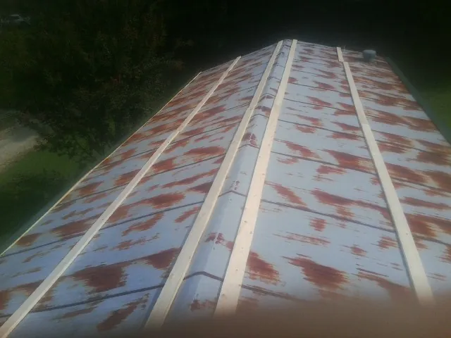 Rusted metal roof panels with new wood purlins before replacement — Storm Damage Roof Repair in Shevlin by Roofing Brothers